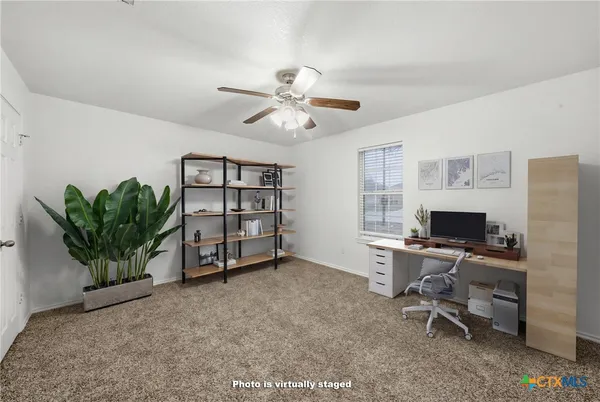 a view of a workspace with furniture and a potted plant