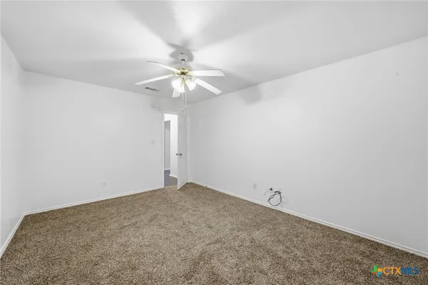 an empty room with a chandelier fan
