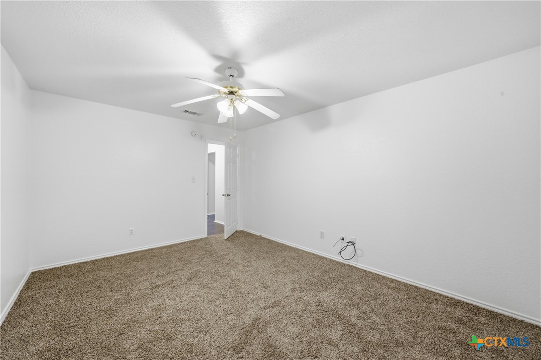 6525 Brooks Drive Temple, TX 76502 - Photo 31 of 37 an empty room with a chandelier fan