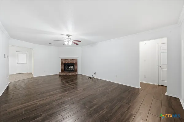 a view of a livingroom with wooden floor and a ceiling fan