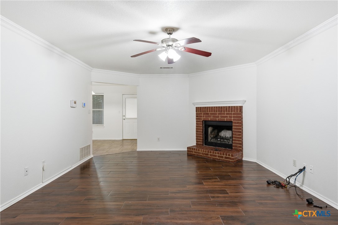 6525 Brooks Drive Temple, TX 76502 - Photo 7 of 37 a view of an empty room with wooden floor fireplace and a window