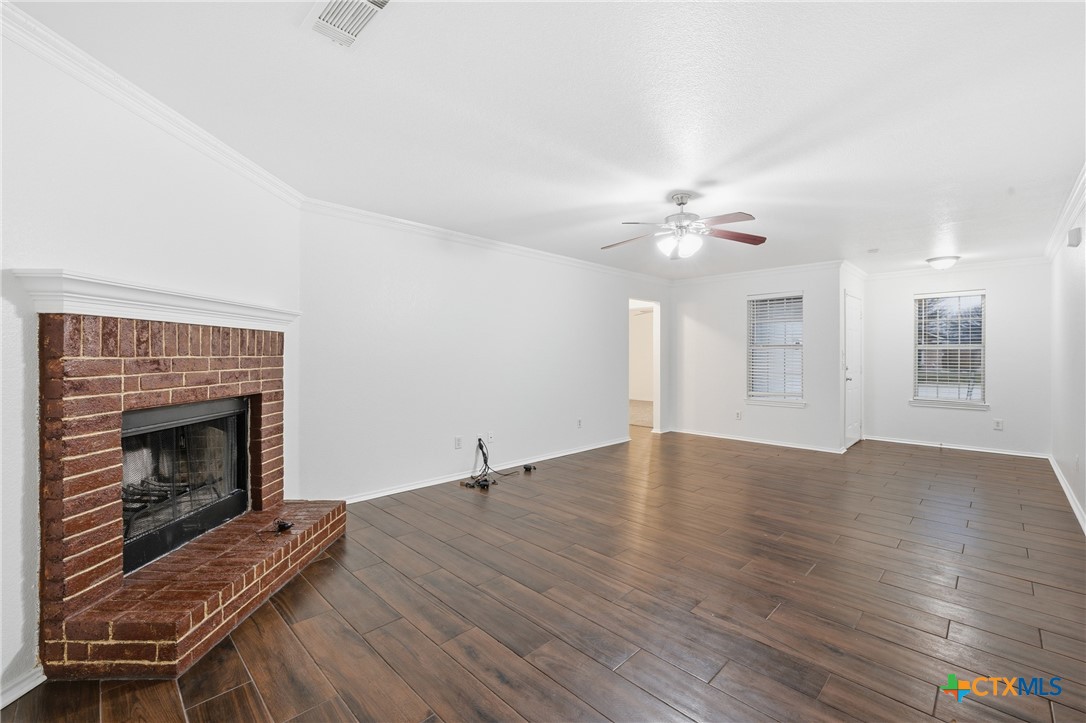 6525 Brooks Drive Temple, TX 76502 - Photo 9 of 37 a view of an empty room with wooden floor fireplace and a window