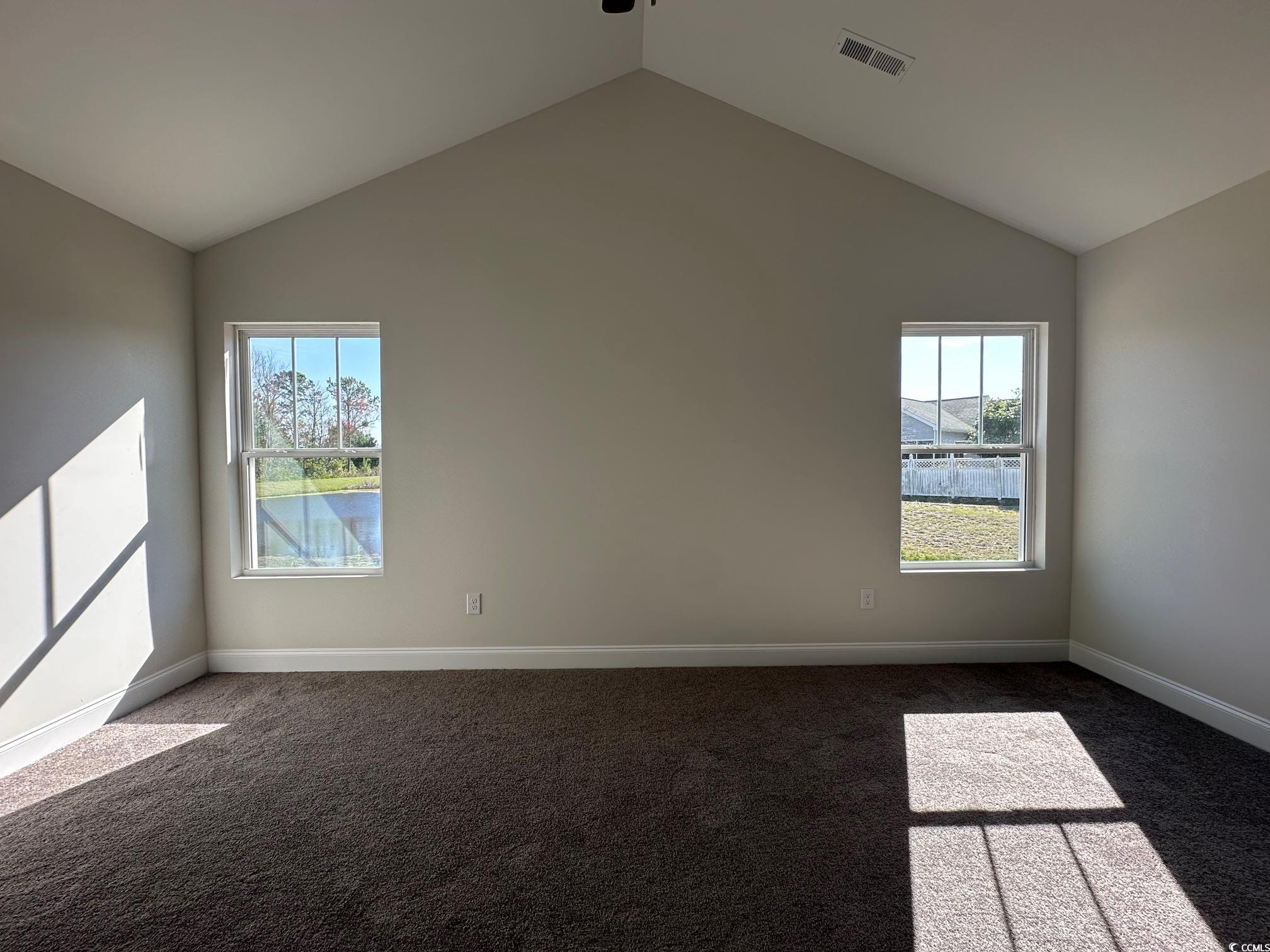 1248 Wehler Court Conway, SC 29526 - Photo 16 of 24 Spare room featuring dark colored carpet, visible vents, lofted ceiling, and plenty of natural light