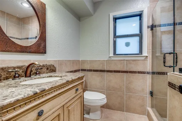 a bathroom with a sink a toilet and a mirror