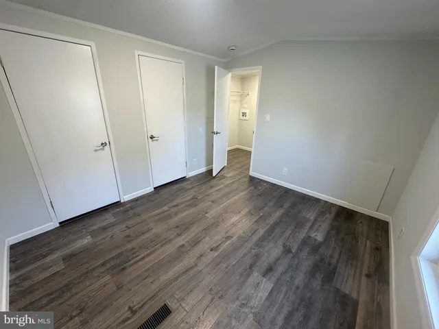 a view of an empty room with wooden floor