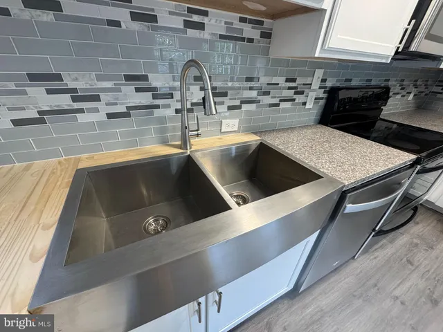 a kitchen with a sink and a stove top oven