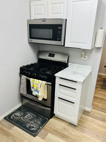 a stove top oven sitting inside of a kitchen