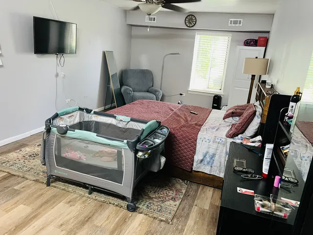 a bedroom with a bed and flat tv screen on the dresser