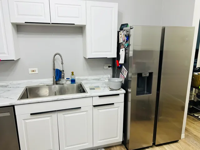 a kitchen with stainless steel appliances granite countertop a sink and a refrigerator
