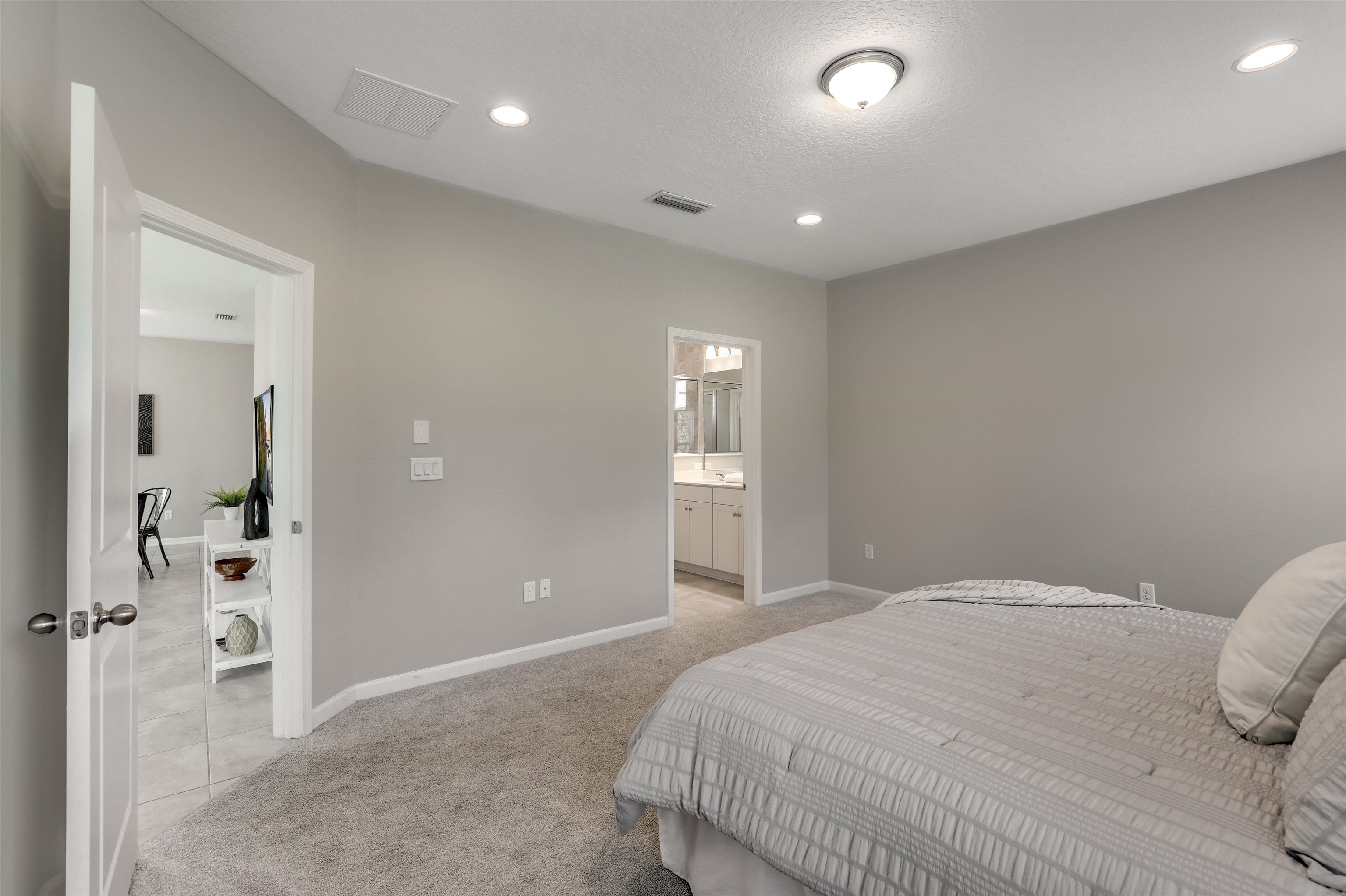 333 Bermudez Way St. Augustine, FL 32095 - Photo 23 of 62 a spacious bedroom with a bed and a chandelier