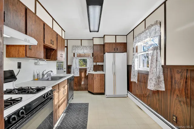 a kitchen with stainless steel appliances granite countertop a refrigerator a stove and a sink