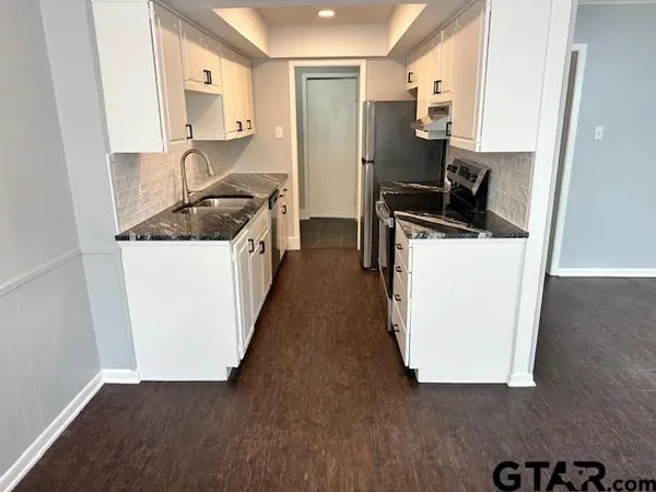 a kitchen with sink cabinets and a stove
