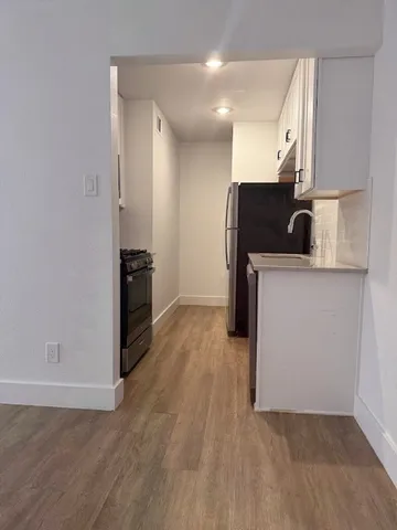 a view of a kitchen with wooden floor and electronic appliances