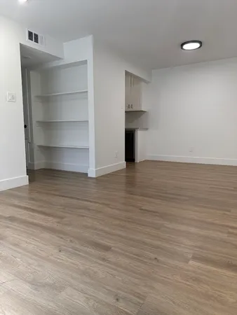 a view of an empty room with a fireplace and cabinet