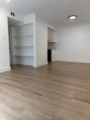 a view of an empty room with a fireplace and cabinet