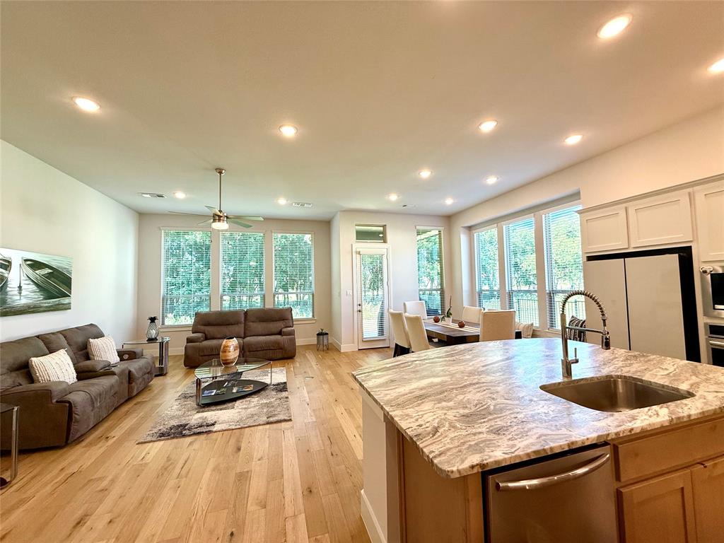 1835 Bell Court Van Alstyne, TX 75495 - Photo 5 of 20 a kitchen with granite countertop a stove a sink a dining table and chairs with wooden floor