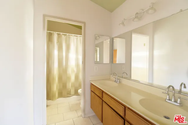 a spacious bathroom with a double vanity sink and a mirror