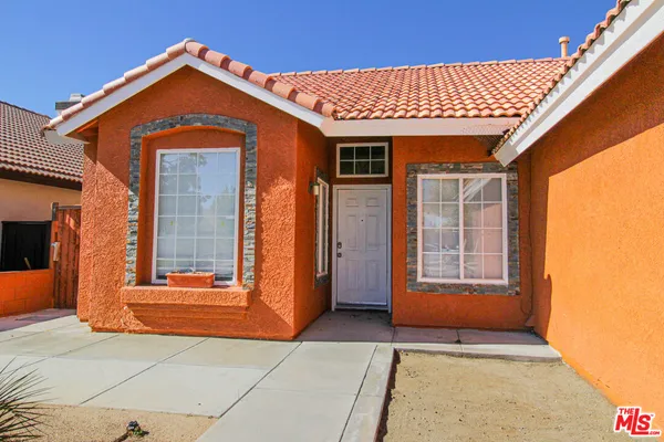 a front view of a house with a blue gate