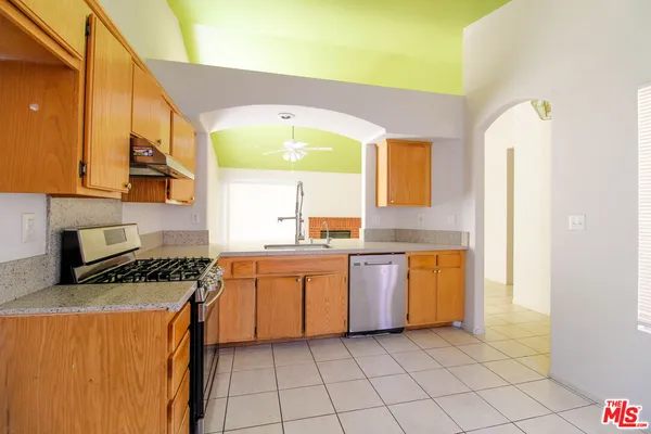 a kitchen with stainless steel appliances a sink a stove top oven a counter space and cabinets