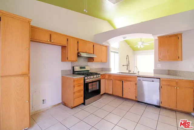 a large kitchen with granite countertop a sink and cabinets