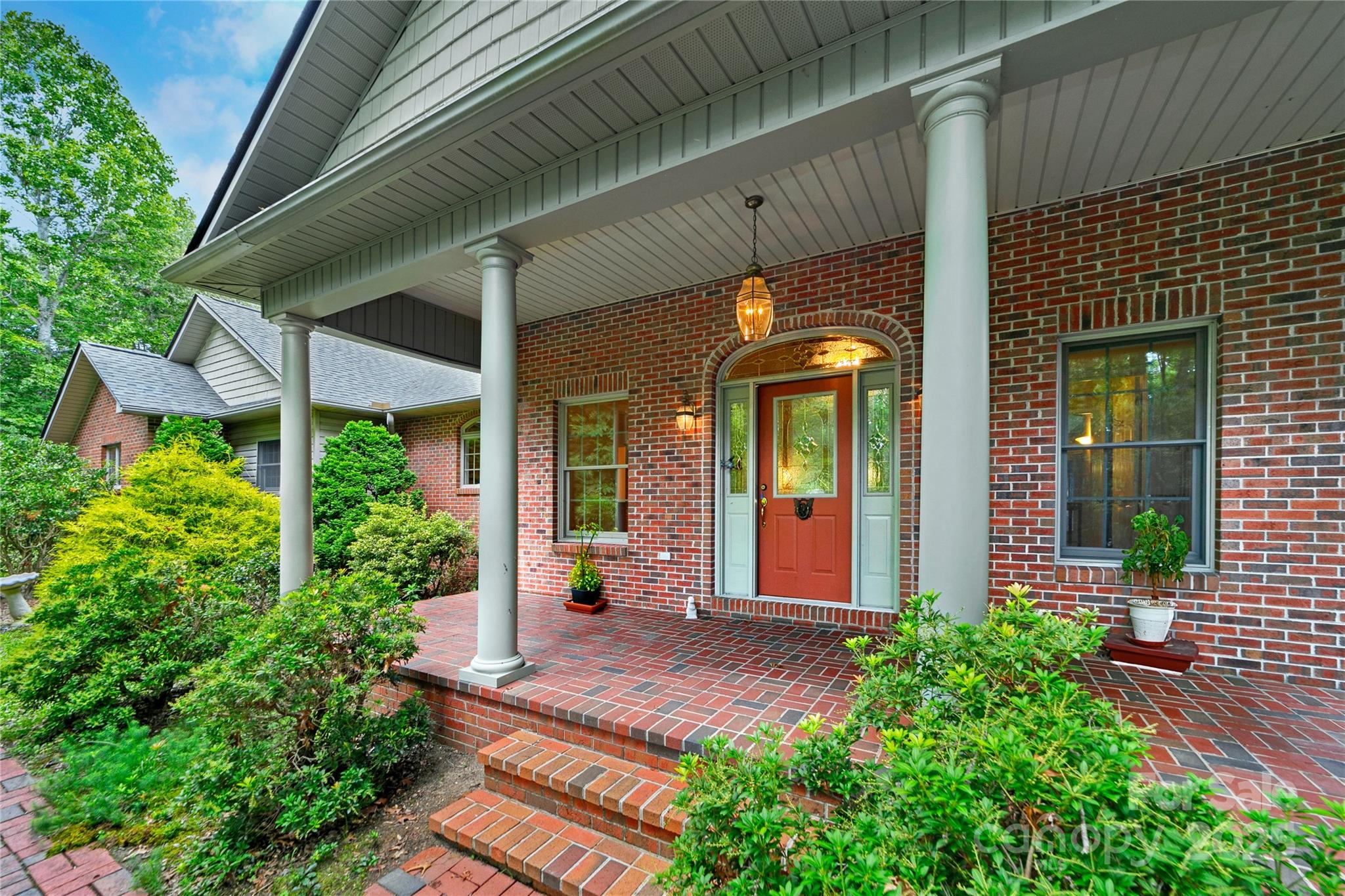 a view of a house with potted plants and a table and chairs