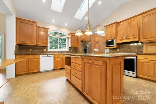 a kitchen with stainless steel appliances granite countertop a stove sink and cabinets