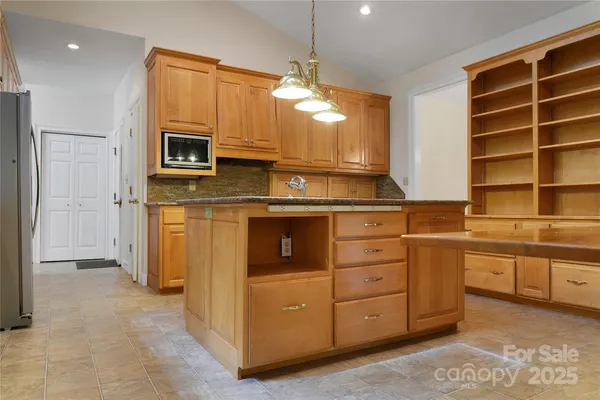 a kitchen with stainless steel appliances granite countertop a stove a sink and a refrigerator