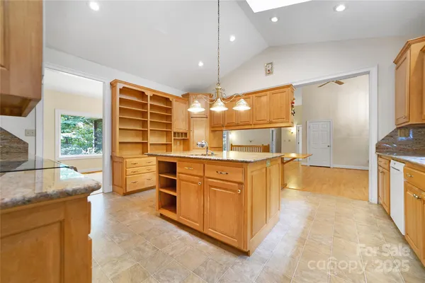 a kitchen with stainless steel appliances granite countertop a sink a stove and a refrigerator