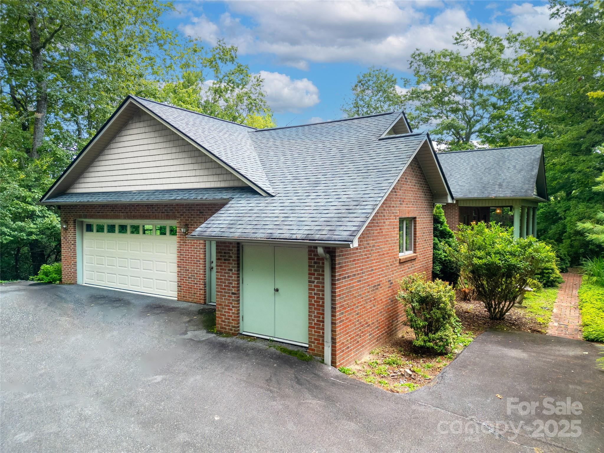 273 Inoli Circle Brevard, NC 28712 - Photo 3 of 47 a front view of a house with a garden and garage