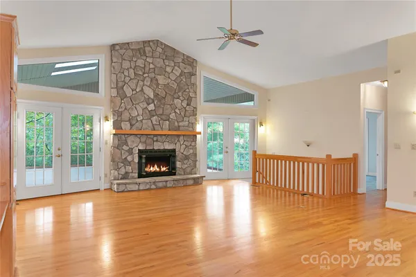 a view of a livingroom with a fireplace wooden floor and window