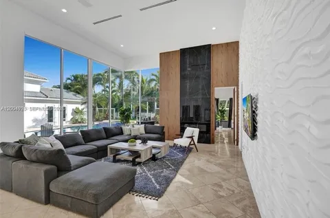 a living room with furniture a large window and stainless steel appliances