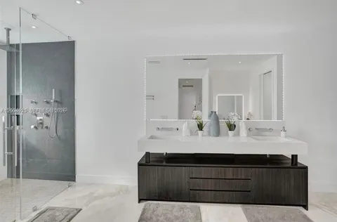 a bathroom with a double vanity sink mirror and shower