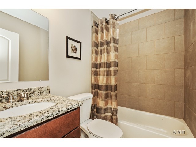 115 Moonlight Road Matteson, IL 60443 - Photo 9 of 10 a bathroom with a granite countertop sink a mirror a bathtub and shower