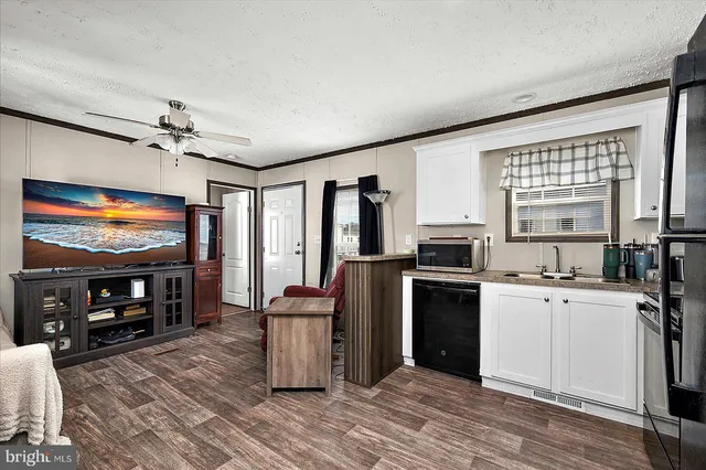 a view of kitchen with microwave a stove and wooden floors