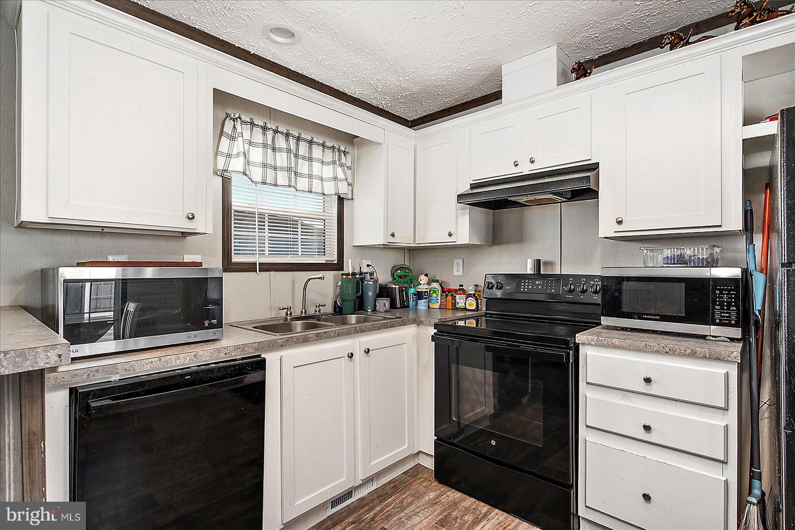 12346 Old Bridge Road, Unit 152 Ocean City, MD 21842 - Photo 18 of 55 a kitchen with a stove and a microwave