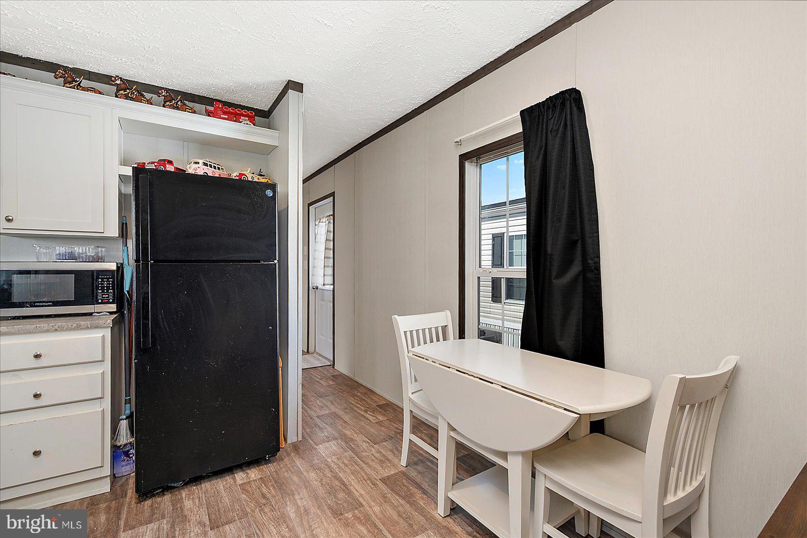12346 Old Bridge Road, Unit 152 Ocean City, MD 21842 - Photo 19 of 55 a kitchen with stainless steel appliances refrigerator dining table and chairs