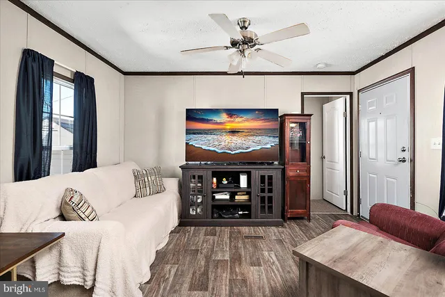 a living room with furniture a flat screen tv and a table