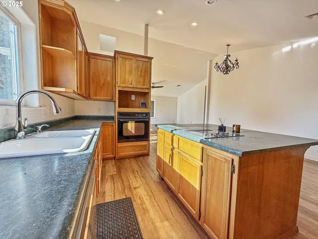 a kitchen with stainless steel appliances granite countertop a sink a stove and a refrigerator