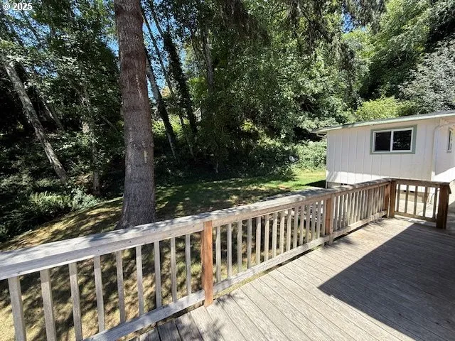 a view of a wooden deck and a yard with wooden fence