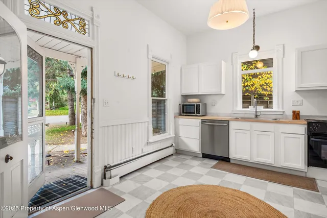 a kitchen with white cabinets and window