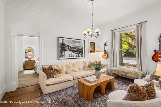 a living room with furniture a chandelier and a window