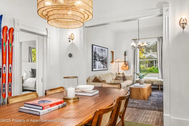 a living room with furniture a chandelier and a table