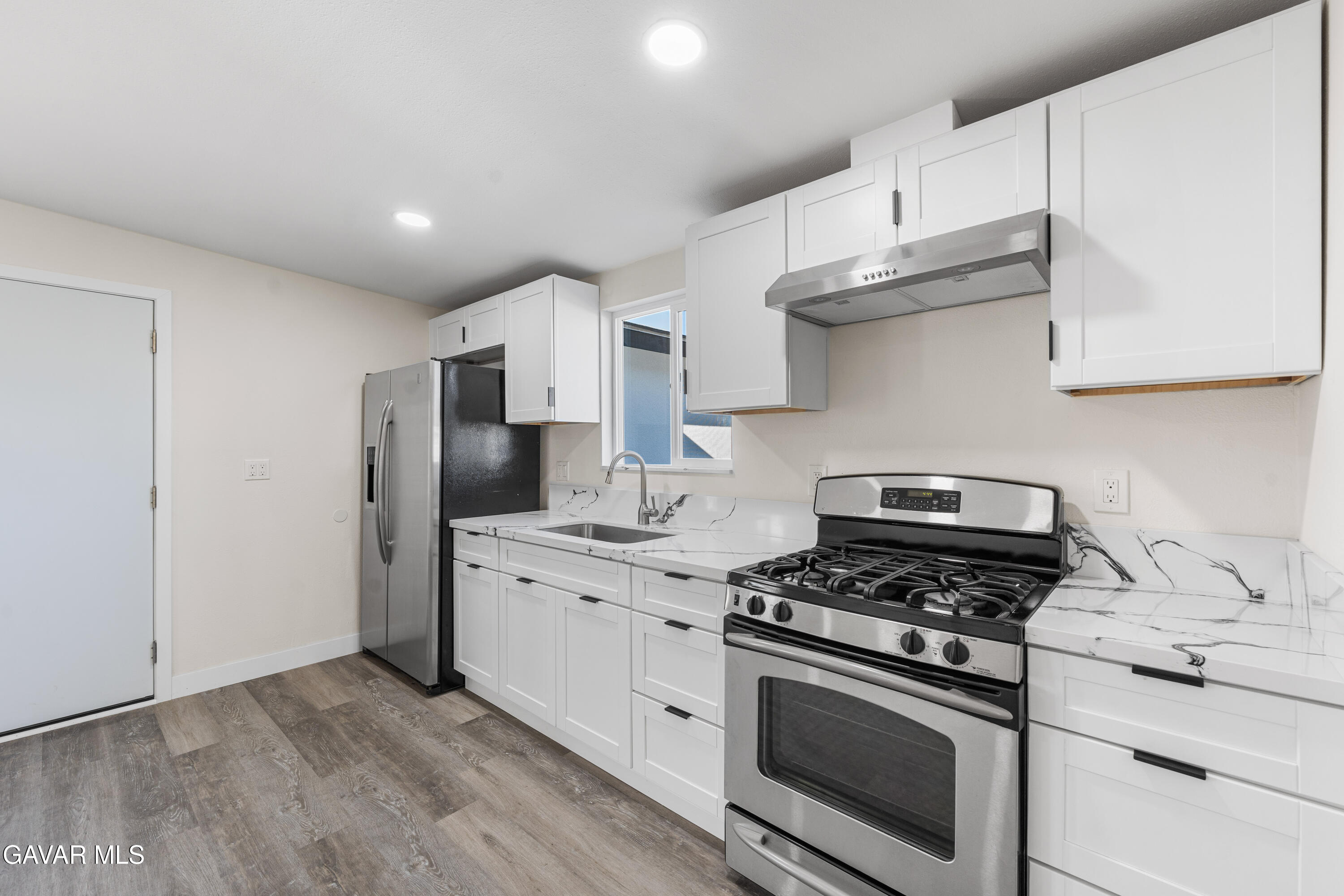 44745 3rd Street East Lancaster, CA 93535 - Photo 17 of 30 a kitchen with stainless steel appliances white cabinets and a stove top oven
