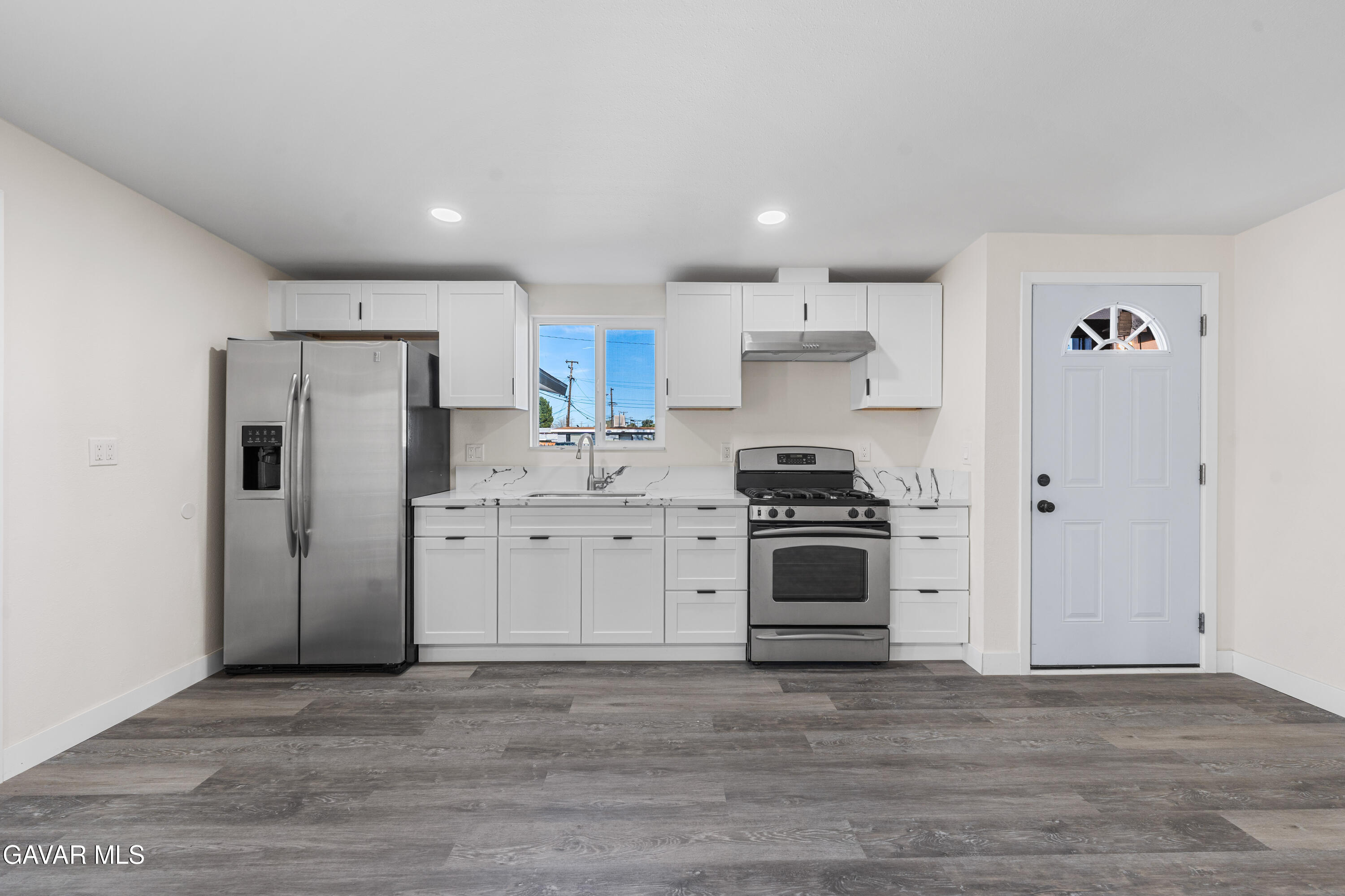 44745 3rd Street East Lancaster, CA 93535 - Photo 21 of 30 a kitchen with stainless steel appliances a refrigerator stove and white cabinets