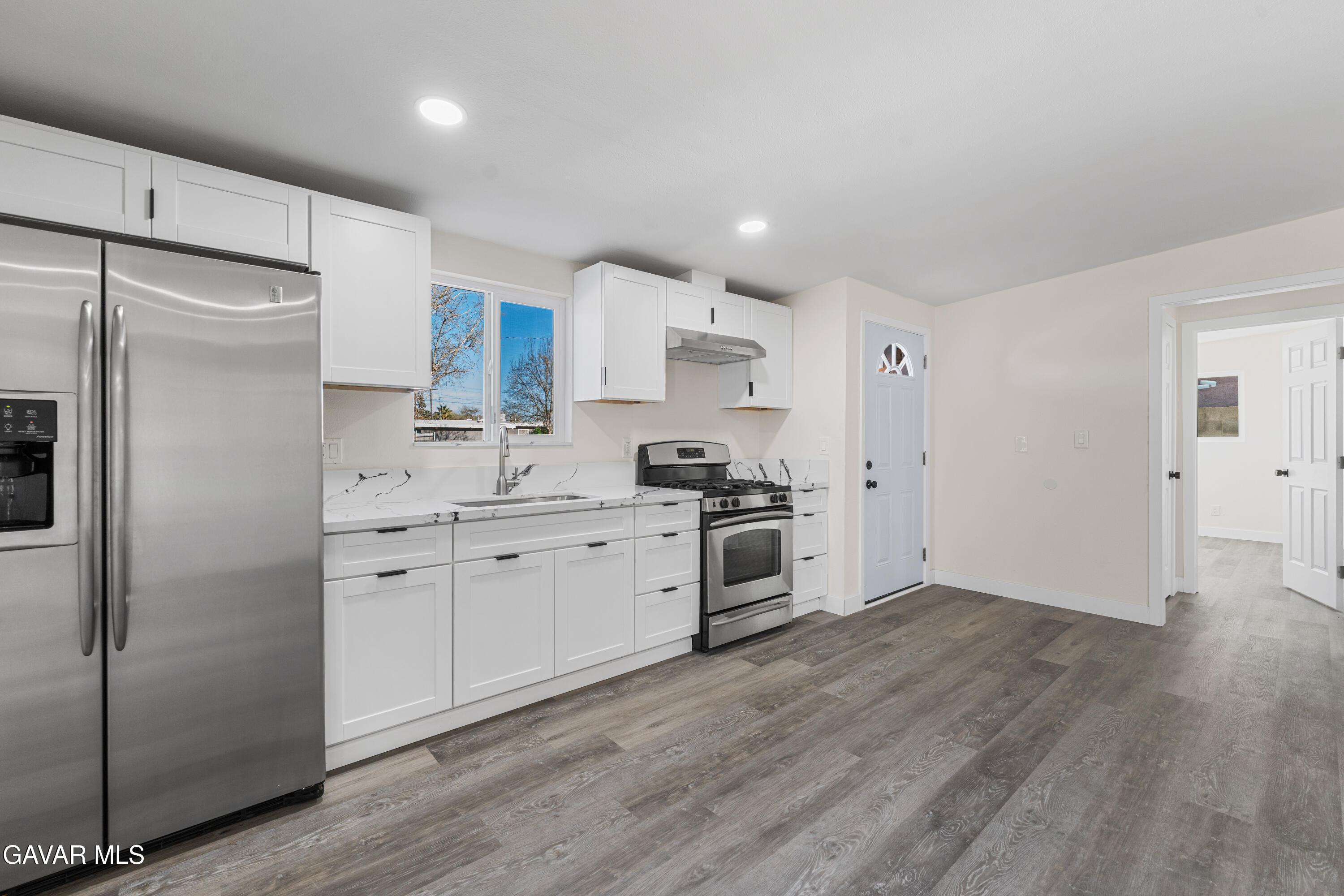 44745 3rd Street East Lancaster, CA 93535 - Photo 22 of 30 a kitchen with granite countertop white cabinets and stainless steel appliances