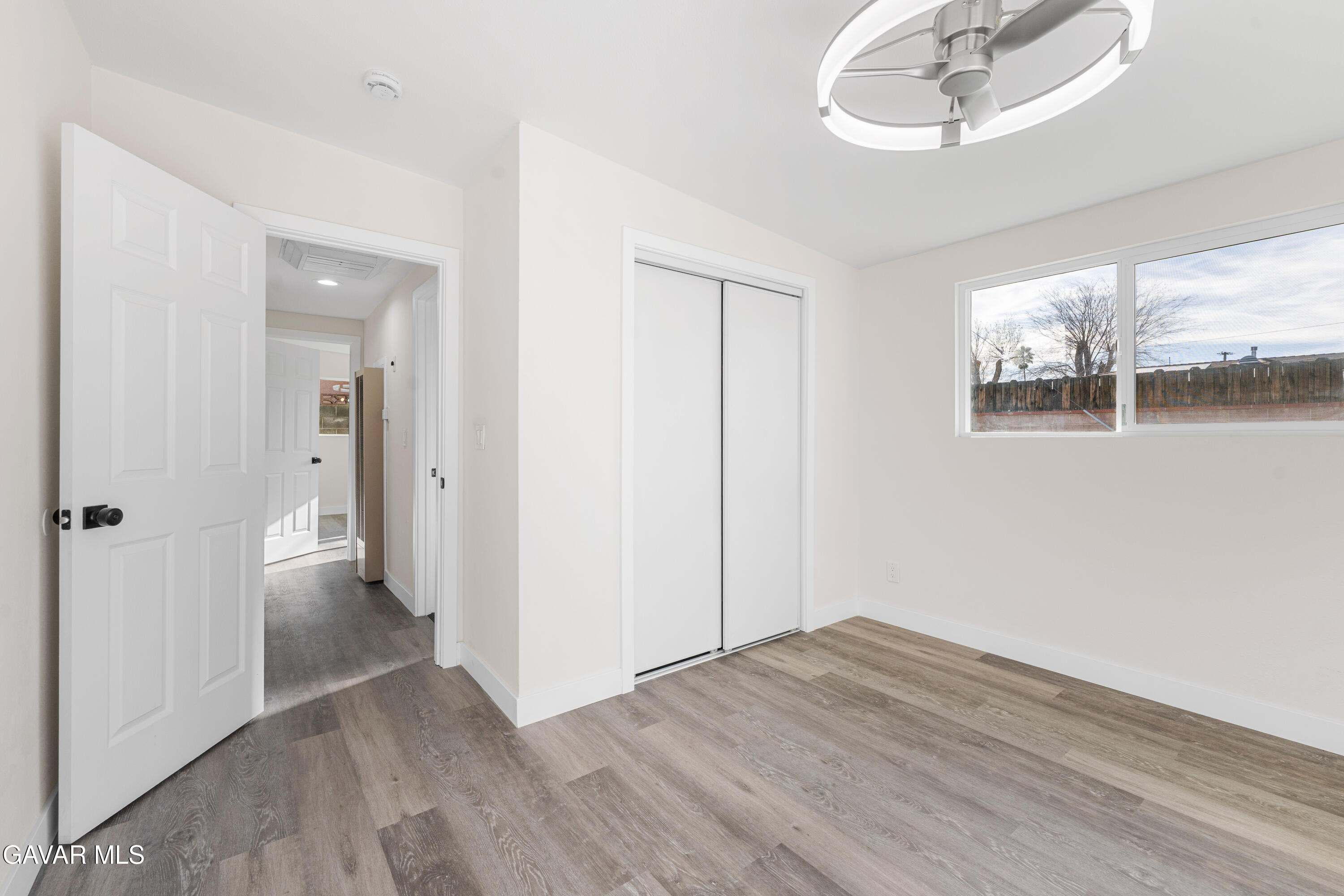 44745 3rd Street East Lancaster, CA 93535 - Photo 9 of 30 an empty room with wooden floor and windows