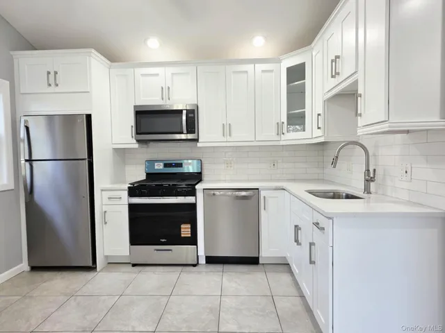 a kitchen with stainless steel appliances granite countertop a refrigerator sink and stove