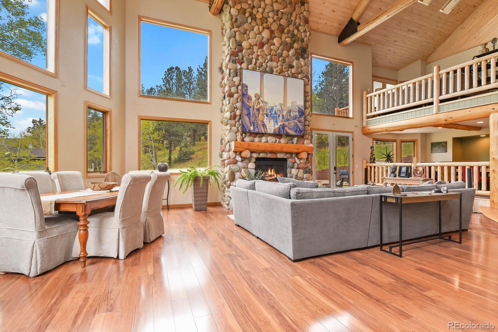 417 Witter Gulch Road Evergreen, CO 80439 - Photo 5 of 50 a living room with fireplace furniture and a large window