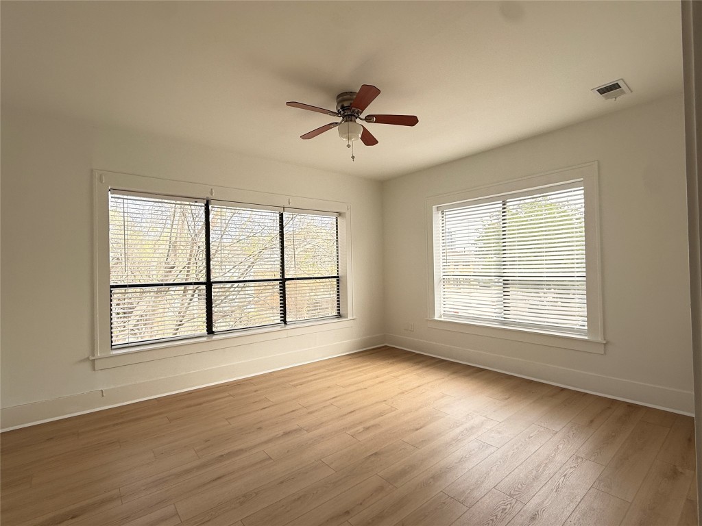 1201 West Gray Street, Unit 3 Houston, TX 77019 - Photo 5 of 10 a view of an empty room with wooden floor and a window
