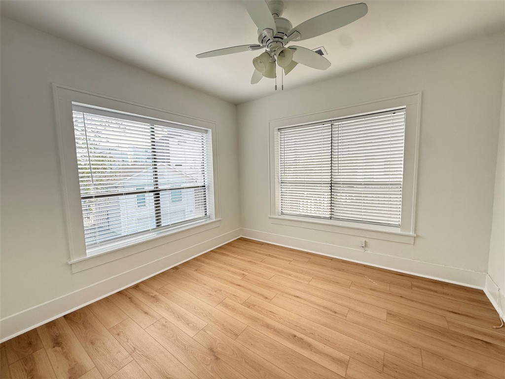 1201 West Gray Street, Unit 3 Houston, TX 77019 - Photo 7 of 10 a view of an empty room with wooden floor and a window